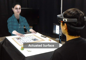 The Physical-virtual Table: Exploring the Effects of a Virtual Human's Physical Influence on Social Interaction